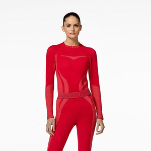 Person wearing a red baselayer for skiing with matching high boots on a white background